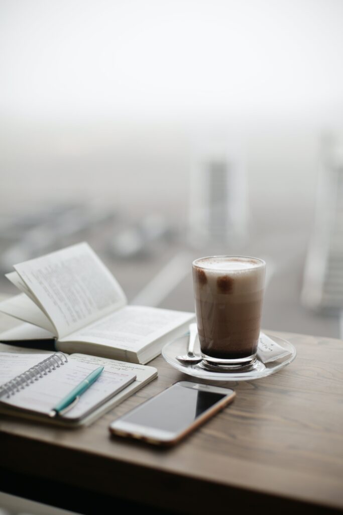 Photo of journaling and drinking coffee as part of a daily routine in eating disorder recovery.