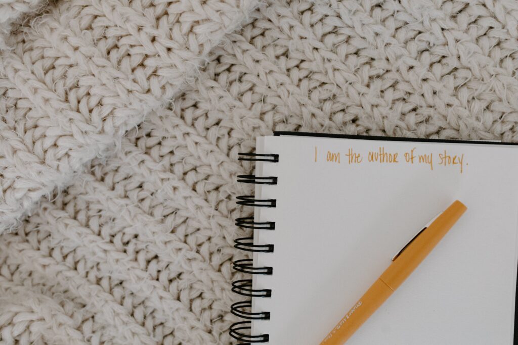 picture of a notebook and a pen with an eating disorder recovery mantra that says, "I am the author of my story."